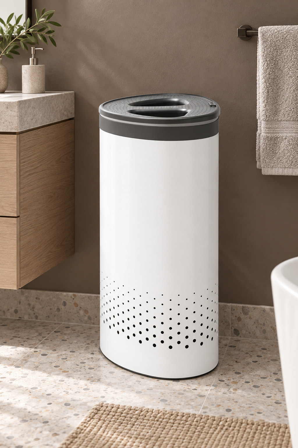 White oval laundry bin with a grey two-opening lid on a terrazzo bathroom floor.