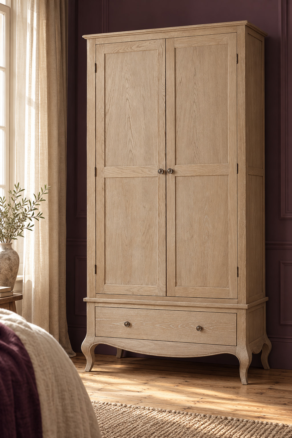 Washed-wood two-door wardrobe with curved feet against an aubergine bedroom wall.
