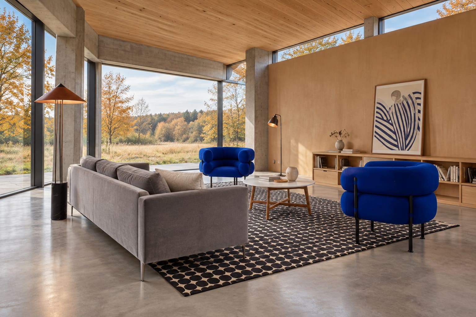 Tall concrete-and-timber great room with grey sofa, blue sculptural chair, patterned rug and large blue-striped print beside glazing.