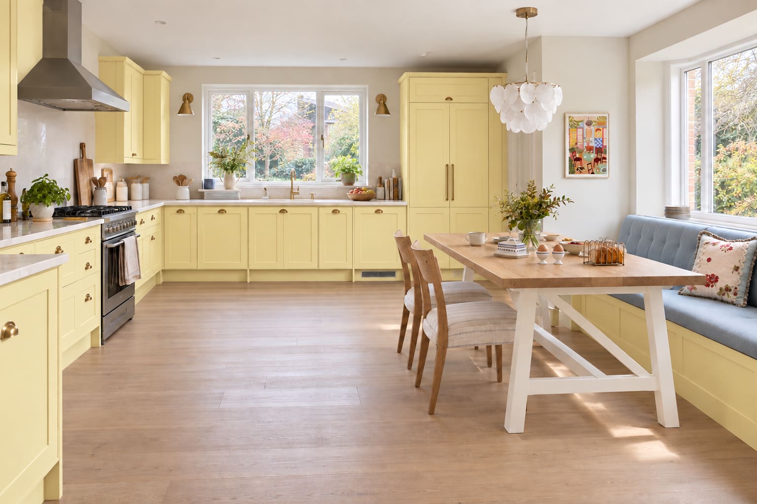 Primrose kitchen and powder-blue breakfast banquette with an oak table, linen dining chairs and blue-patterned breakfast ceramics.