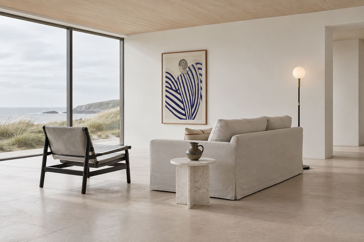 White coastal living room with restrained seating and a large blue-striped print as the principal colour accent.