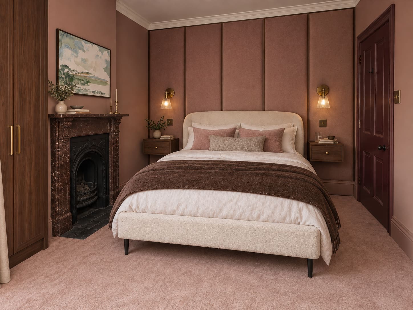 Dusty-rose bedroom with walnut fitted wardrobe and bedside drawers, upholstered wall panels, an ivory double bed, ribbed glass reading lights and a preserved fireplace.